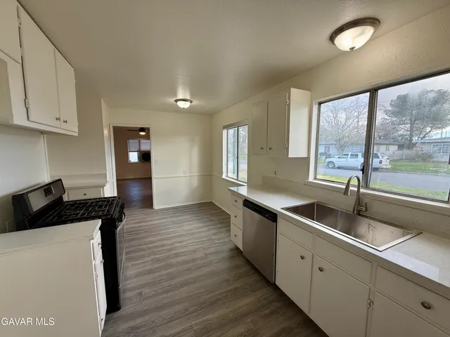 a kitchen with granite countertop a sink and a stove top oven