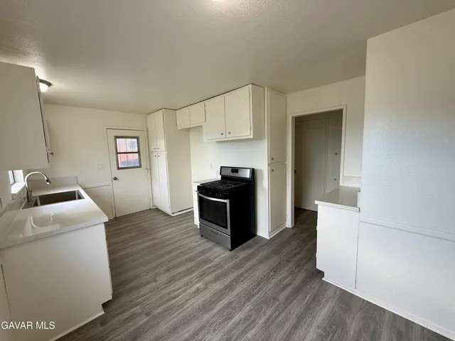 a kitchen with sink a refrigerator and wooden floor