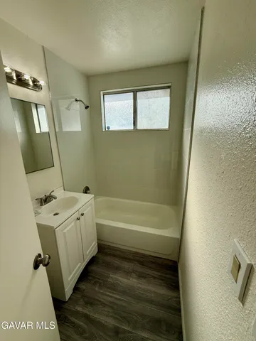 a bathroom with a tub sink and mirror