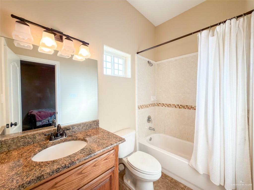 208 North 15th Street Hidalgo, TX 78557 - Photo 25 of 26 a bathroom with a granite countertop sink toilet and shower
