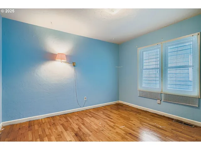 a view of empty room with wooden floor