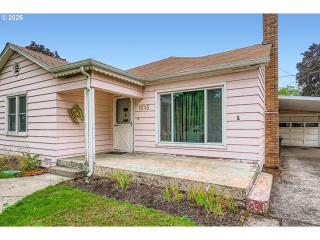 a view of a house with a small yard and wooden fence