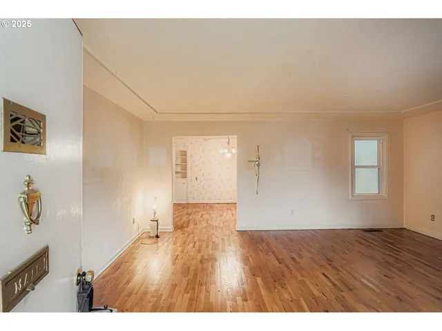 a view of an empty room with wooden floor
