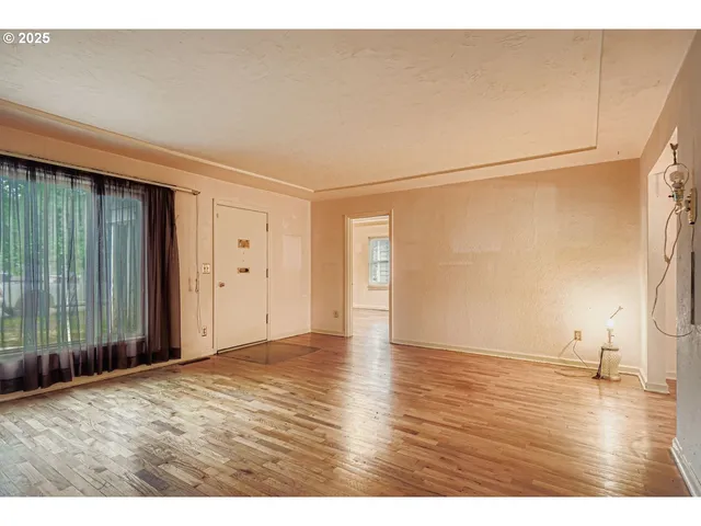 a view of an empty room with wooden floor