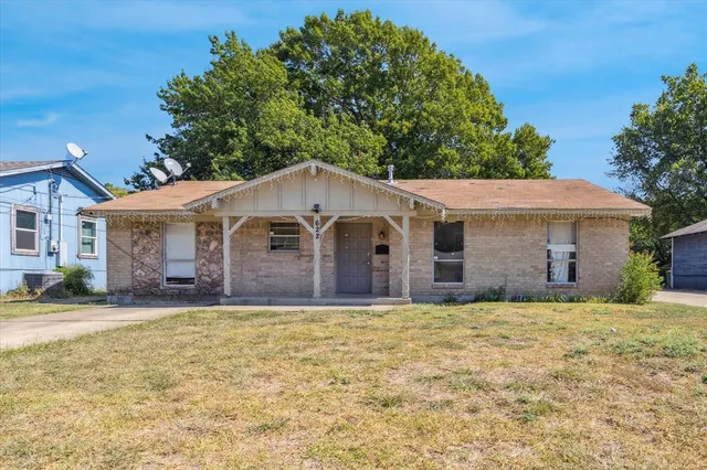 a view of a yard in front of a house with large tree