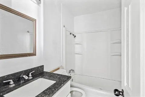 a bathroom with a granite countertop sink toilet and shower