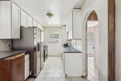 a kitchen with stainless steel appliances granite countertop a refrigerator and a stove