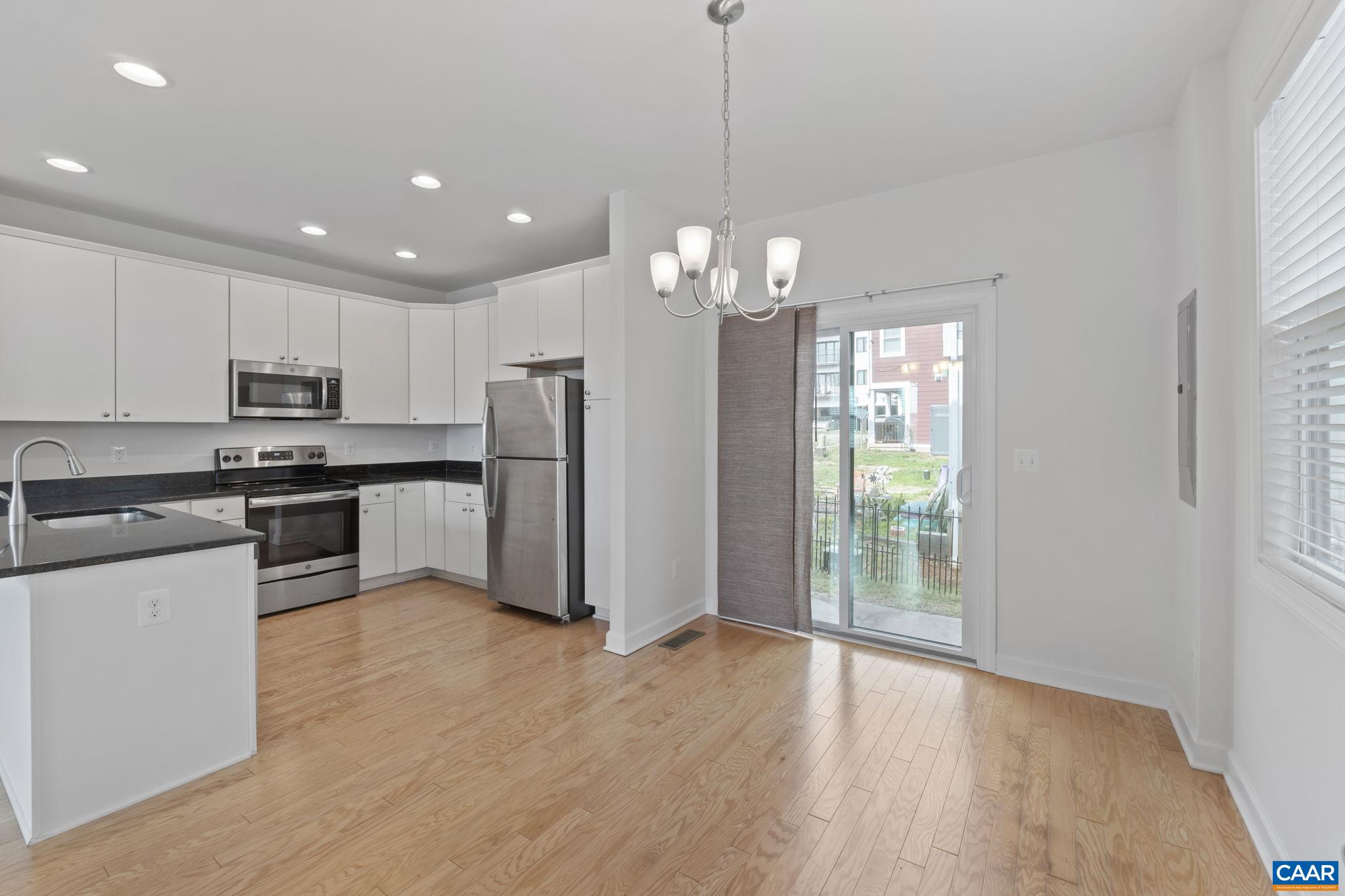 1429 Midland Street Charlottesville, VA 22902 - Photo 16 of 33 a kitchen with stainless steel appliances granite countertop a refrigerator a sink dishwasher a stove and white cabinets with wooden floor