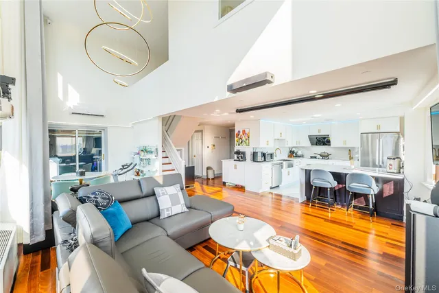 a living room with furniture kitchen view and a large window
