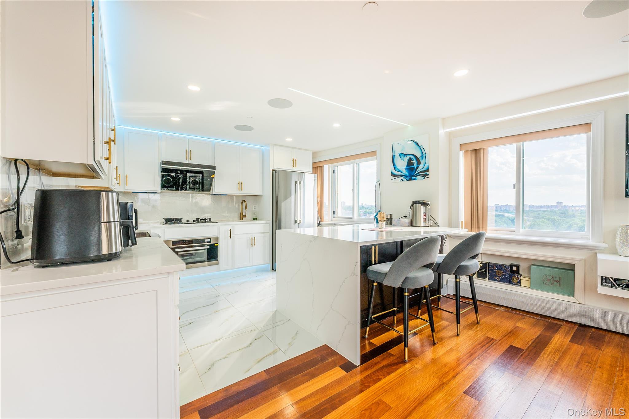 43-18 Main Street, Unit 12A Queens, NY 11355 - Photo 18 of 32 a living room with stainless steel appliances kitchen island granite countertop furniture and a wooden floor
