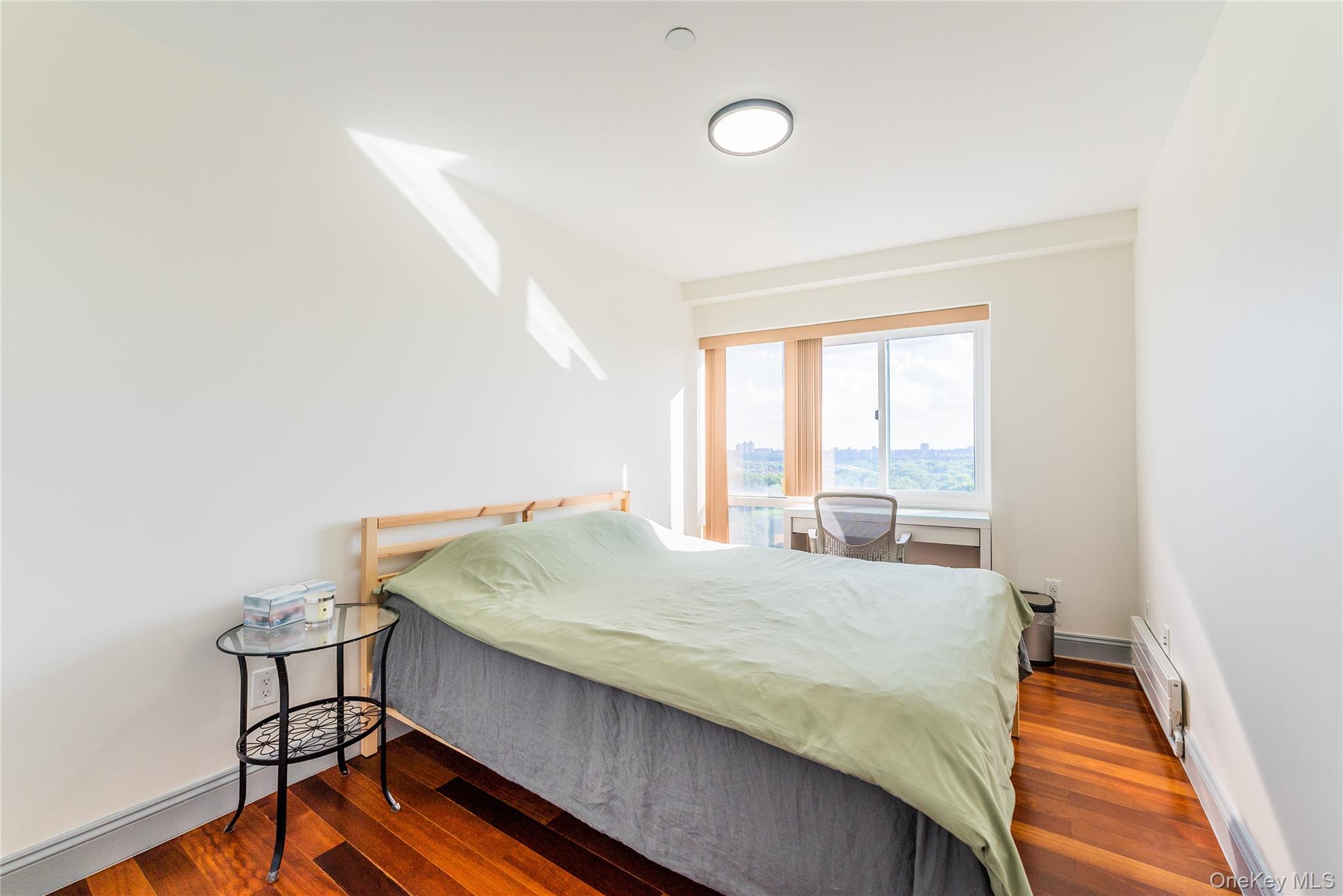 43-18 Main Street, Unit 12A Queens, NY 11355 - Photo 25 of 32 a bed sitting in a bedroom next to a window