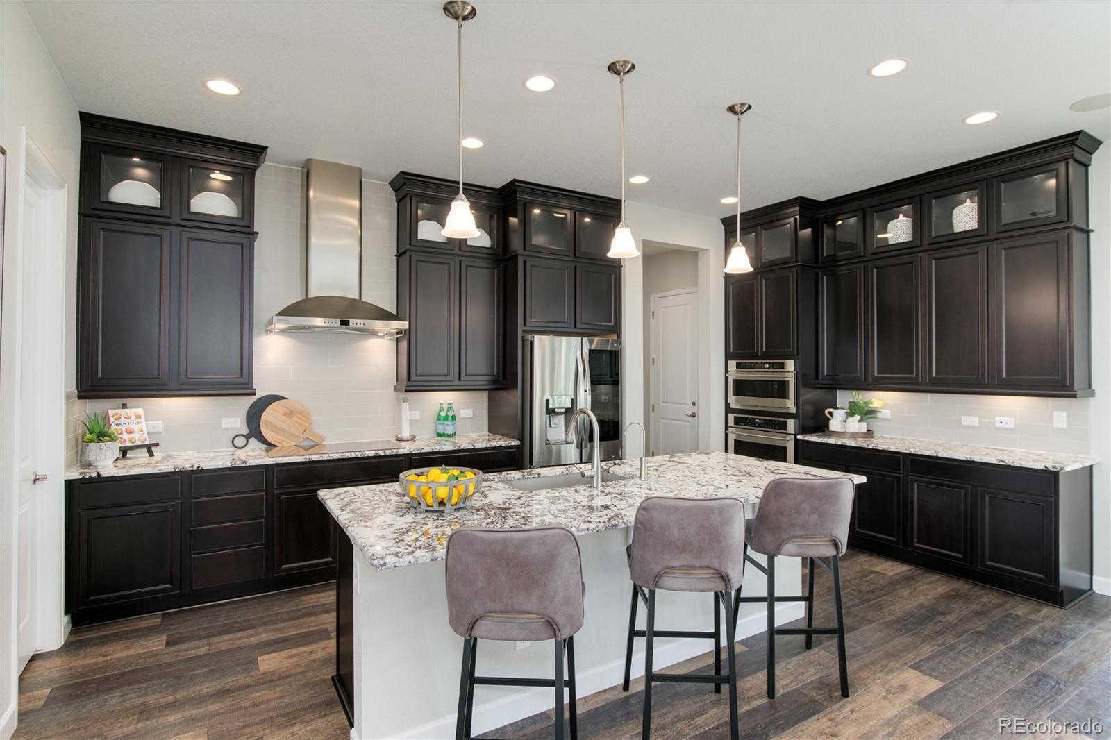 1165 Brocade Drive Highlands Ranch, CO 80126 - Photo 1 of 40 a kitchen with stainless steel appliances kitchen island granite countertop a sink and cabinets