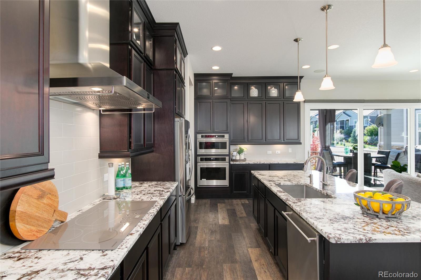1165 Brocade Drive Highlands Ranch, CO 80126 - Photo 16 of 40 a kitchen with granite countertop a sink a stove and cabinets