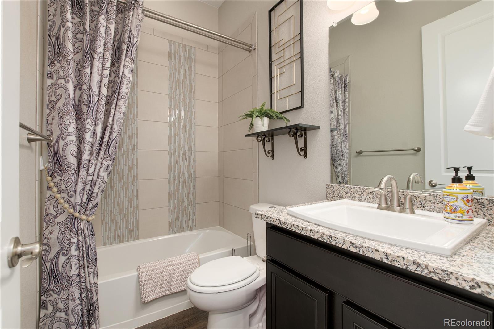 1165 Brocade Drive Highlands Ranch, CO 80126 - Photo 28 of 40 a bathroom with a granite countertop sink toilet and shower