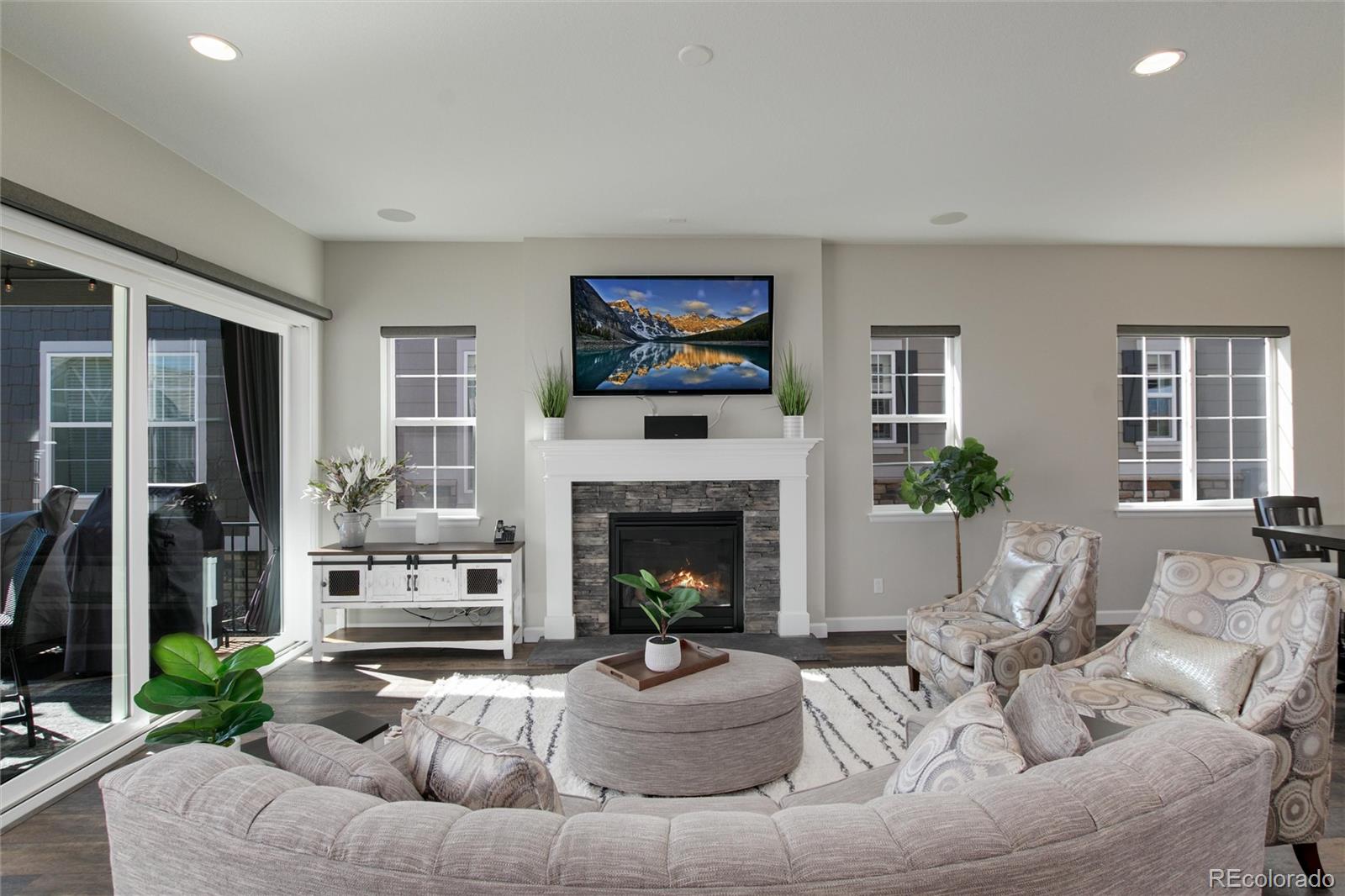 1165 Brocade Drive Highlands Ranch, CO 80126 - Photo 5 of 40 a living room with furniture a fireplace and a floor to ceiling window
