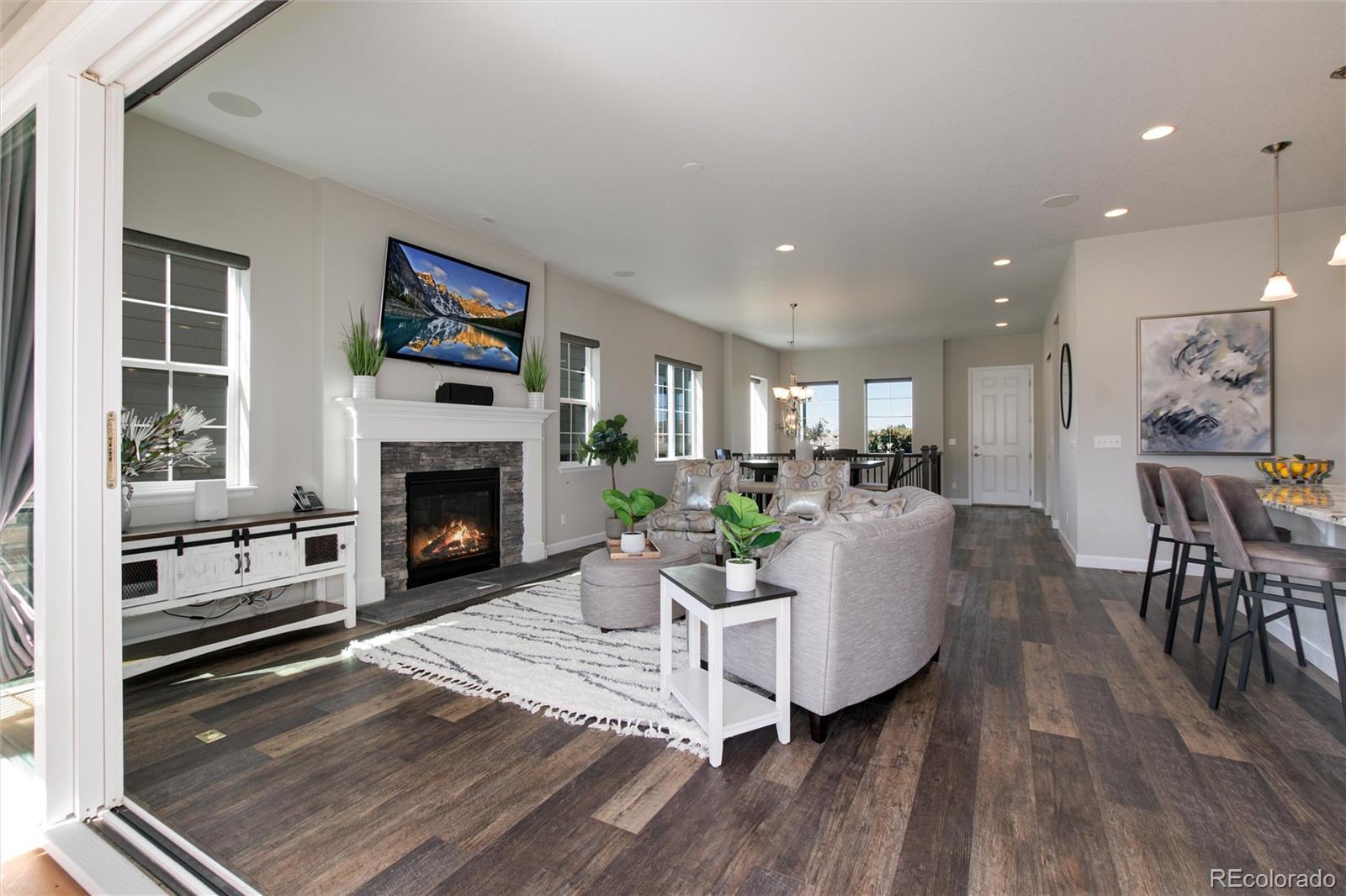 1165 Brocade Drive Highlands Ranch, CO 80126 - Photo 6 of 40 a living room with furniture a fireplace and a table