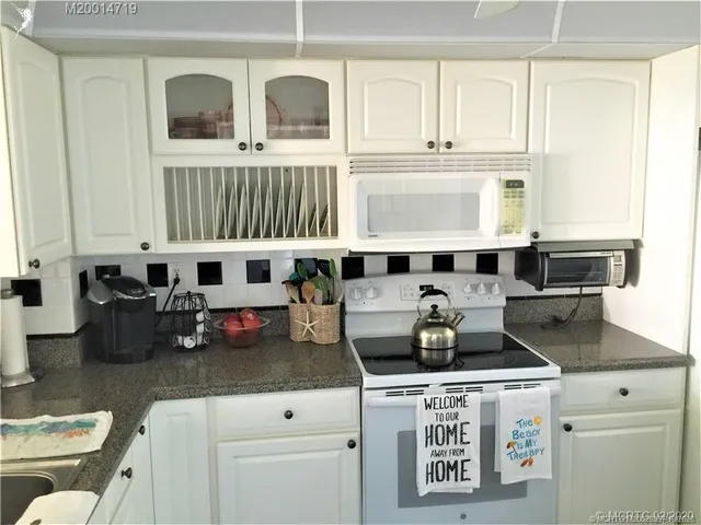 a kitchen with a stove and white cabinets