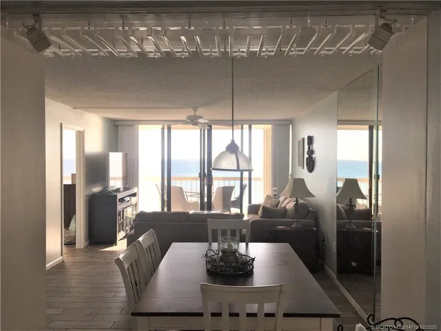 a view of a dining room with furniture large window and chandelier