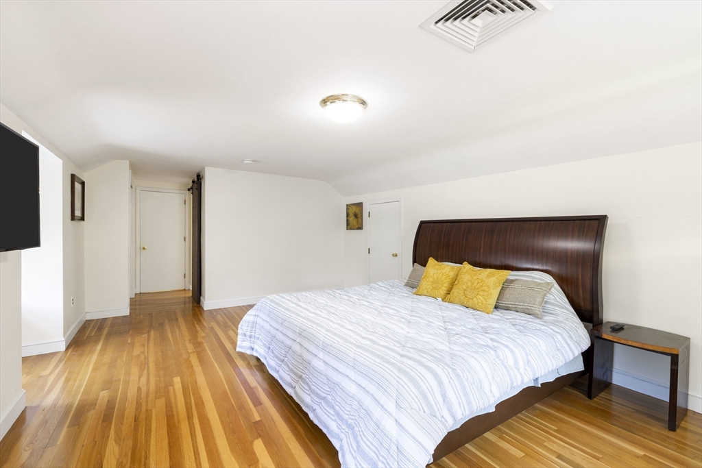 3 Hadley Road Lexington, MA 02420 - Photo 15 of 30 a bedroom with a bed and a flat screen tv
