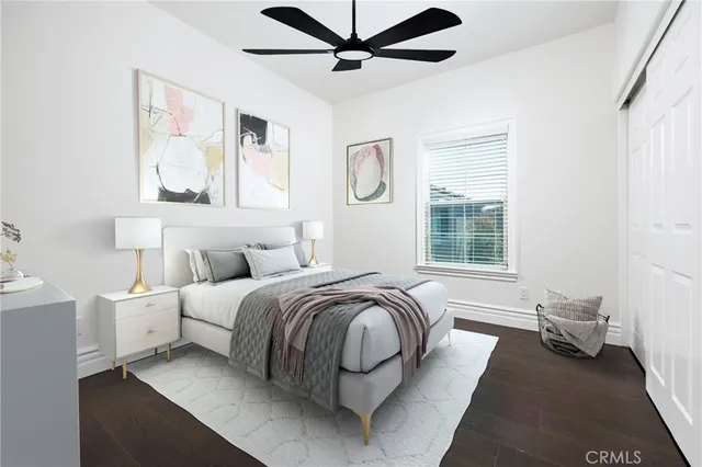 a spacious bedroom with a bed and wooden floor