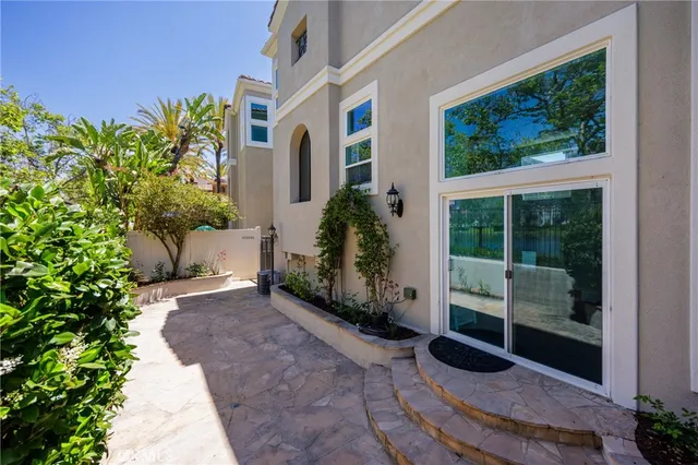 a view of a white house with a tree and plants