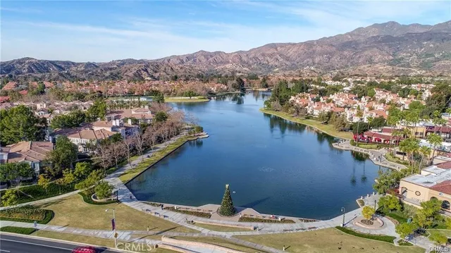 an aerial view of a house with a garden and lake view