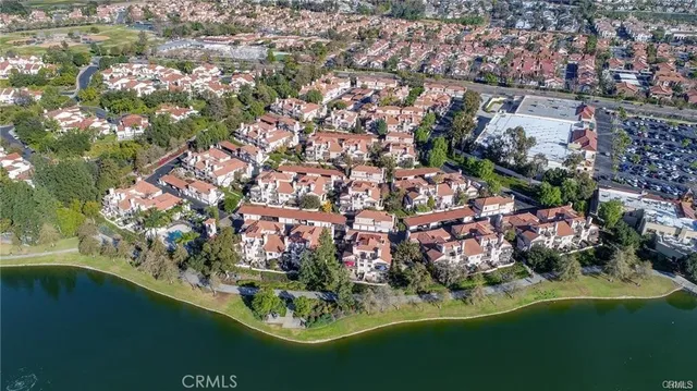 an aerial view of residential houses with outdoor space and trees