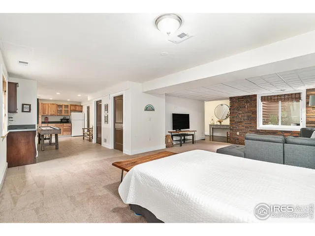 a living room with stainless steel appliances furniture and kitchen view