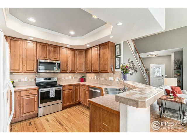 a kitchen with stainless steel appliances granite countertop a stove top oven a sink dishwasher and white cabinets