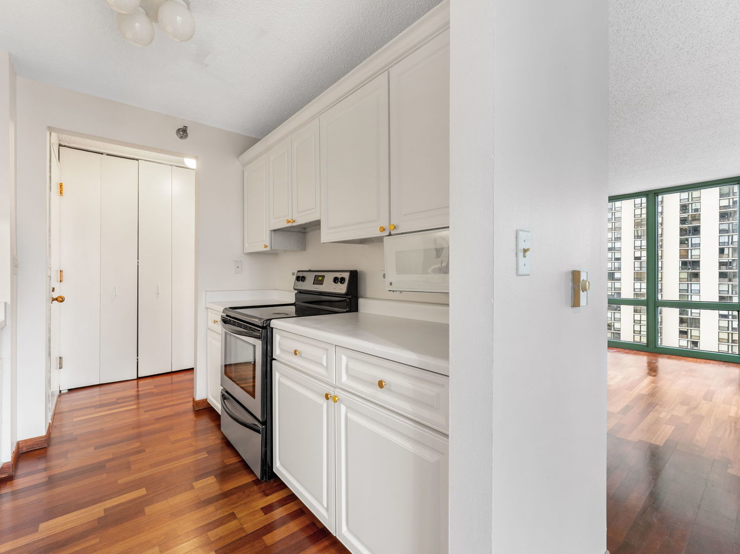 111 West Maple Street, Unit 1401 Chicago, IL 60610 - Photo 4 of 22 a kitchen with stainless steel appliances a white cabinets and wooden floor