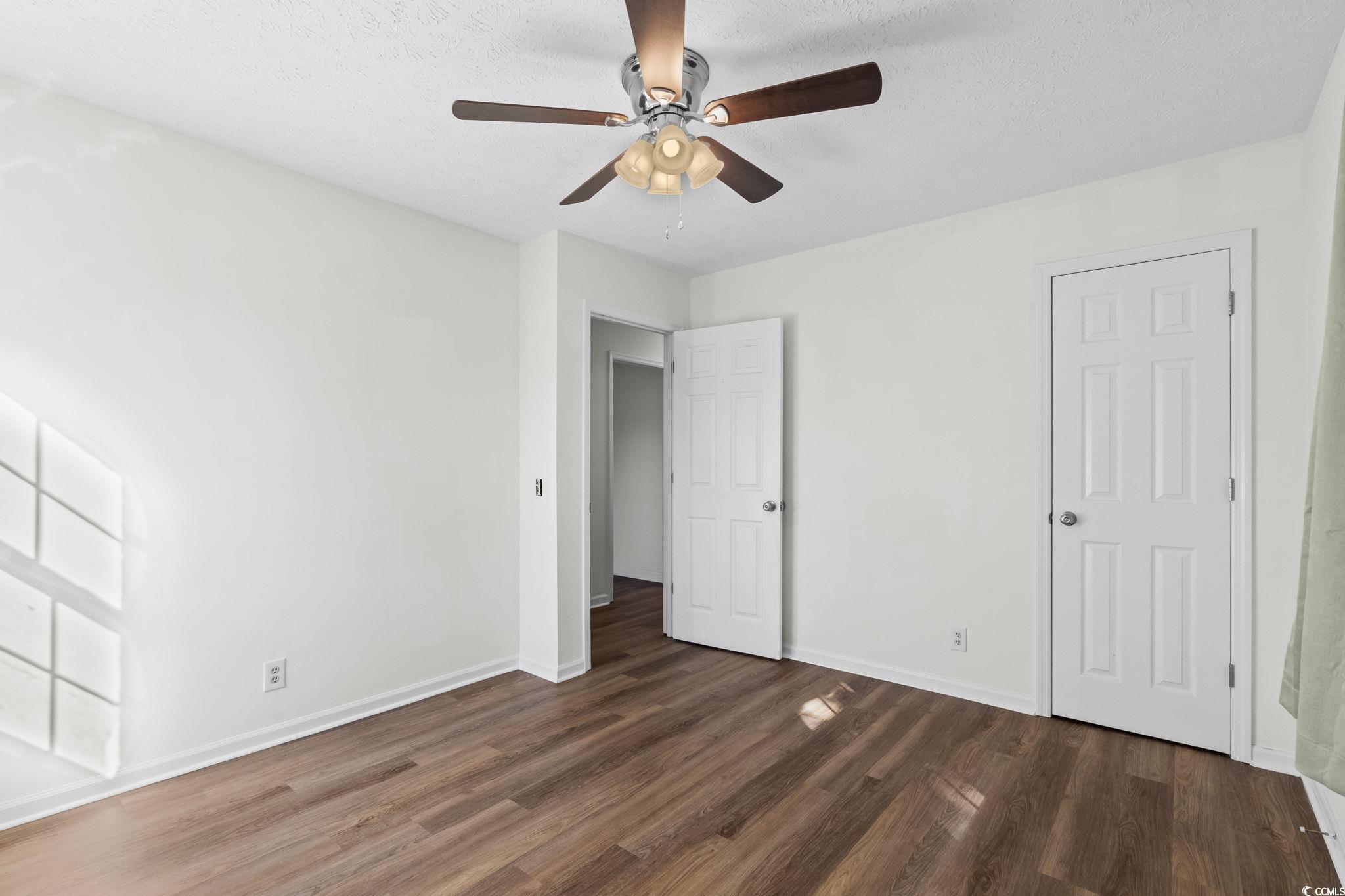 1996 Heritage Road Loris, SC 29569 - Photo 24 of 40 Unfurnished bedroom featuring dark wood finished floors, ceiling fan, and a textured ceiling