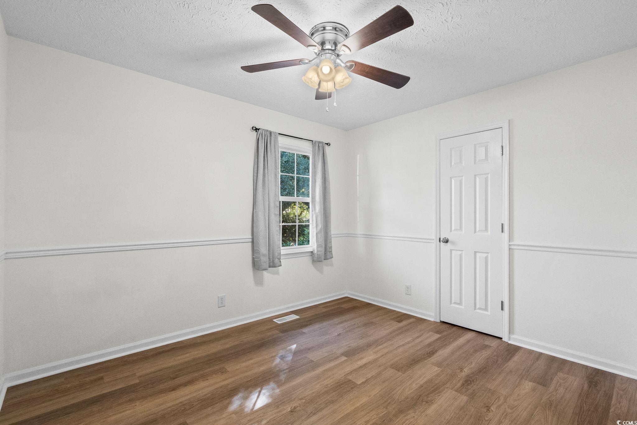 1996 Heritage Road Loris, SC 29569 - Photo 25 of 40 Empty room with wood finished floors and a textured ceiling