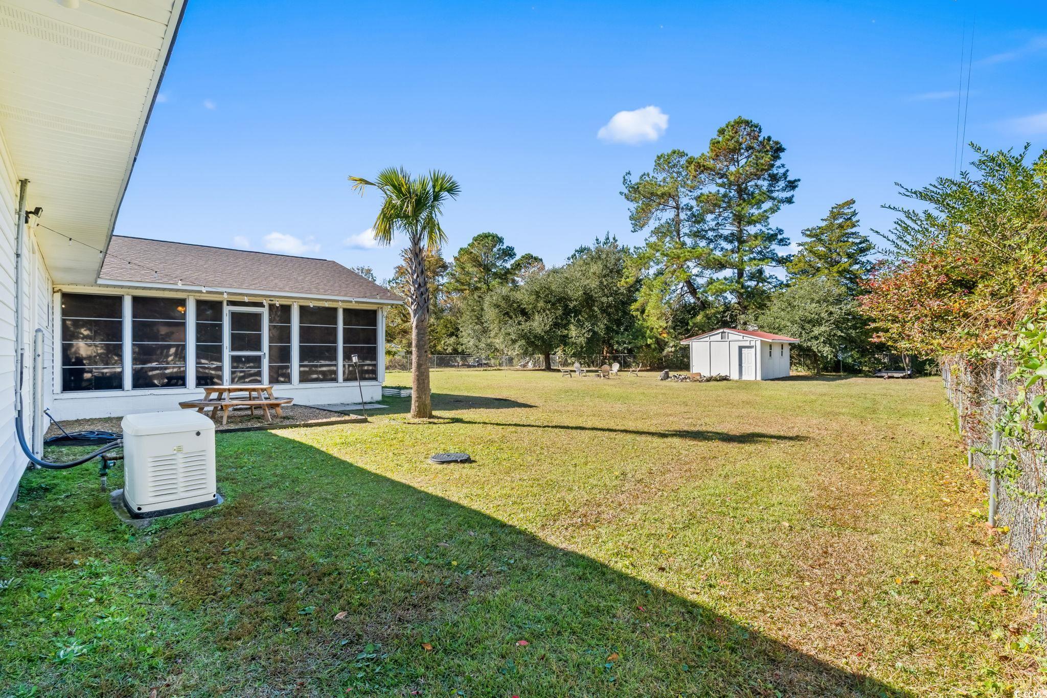 1996 Heritage Road Loris, SC 29569 - Photo 31 of 40 View of grassy yard featuring a sunroom and a storage shed