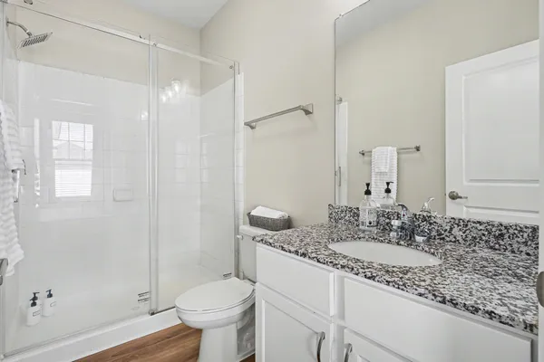 a bathroom with a granite countertop sink toilet and shower