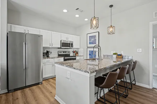 a kitchen with stainless steel appliances granite countertop a kitchen island hardwood floor and a sink
