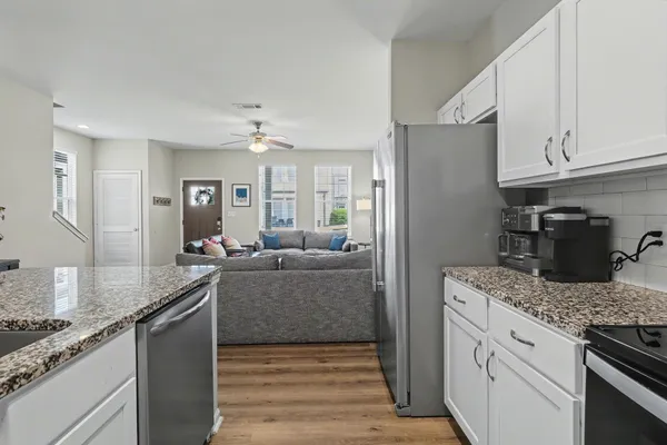 a kitchen with stainless steel appliances granite countertop a sink stove and refrigerator