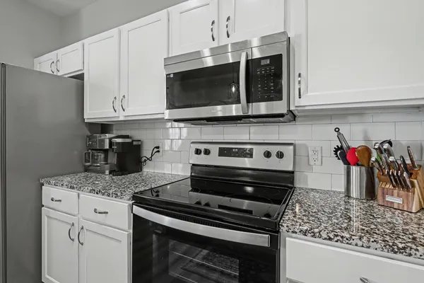 a kitchen with stainless steel appliances granite countertop a stove and a microwave