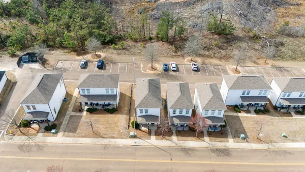an aerial view of residential houses with outdoor space and parking