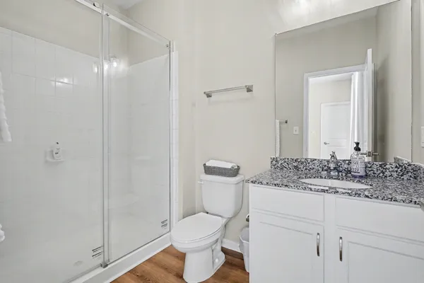 a bathroom with a granite countertop sink toilet and shower