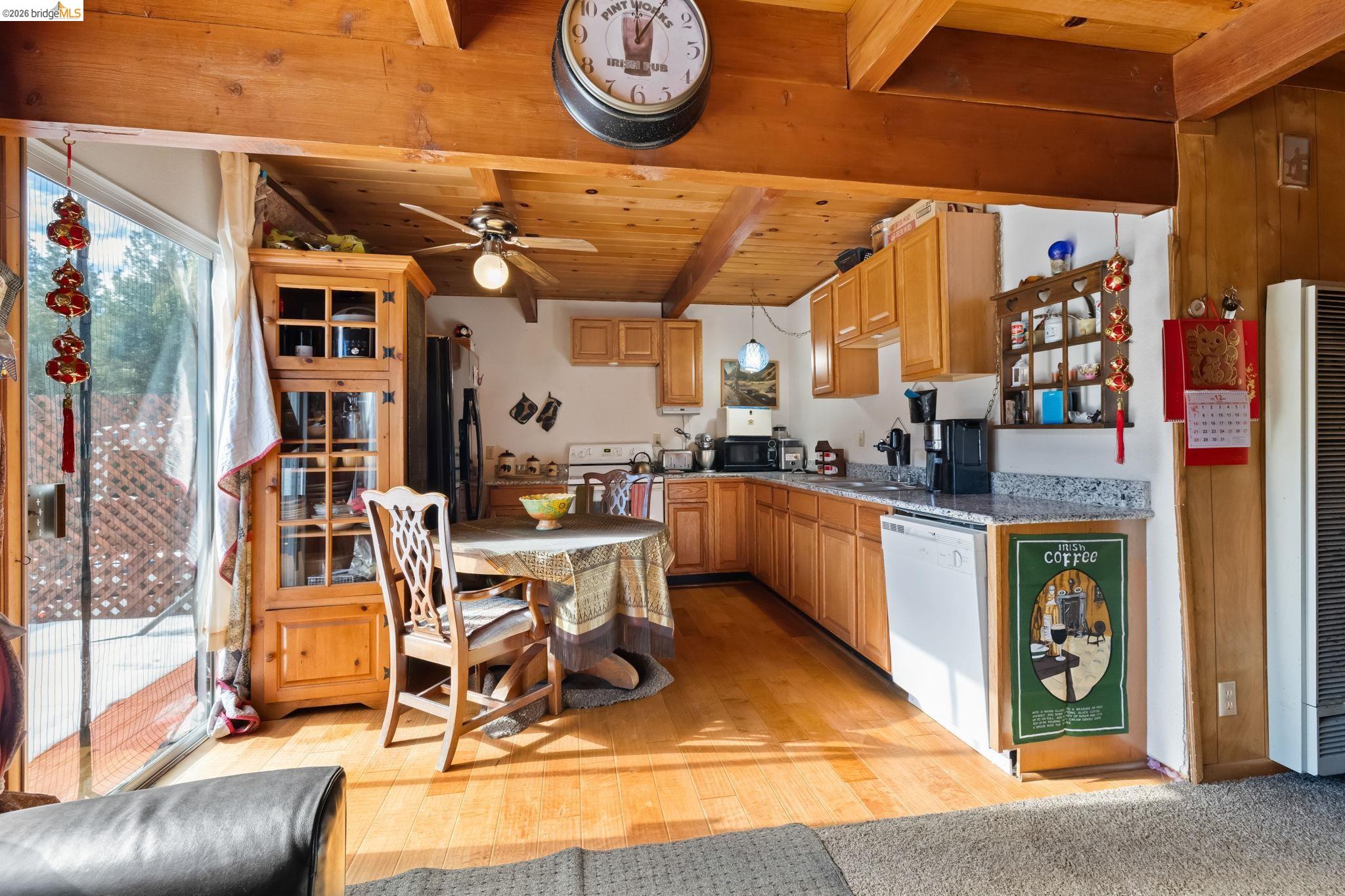26039 Long Barn Road Long Barn, CA 95335 - Photo 10 of 27 Kitchen with a heating unit, black appliances, a wooden ceiling with exposed beams, light wood-style flooring, and a ceiling fan