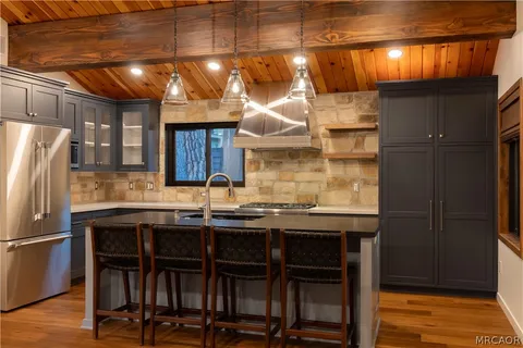a kitchen with stainless steel appliances granite countertop a sink stove and cabinets