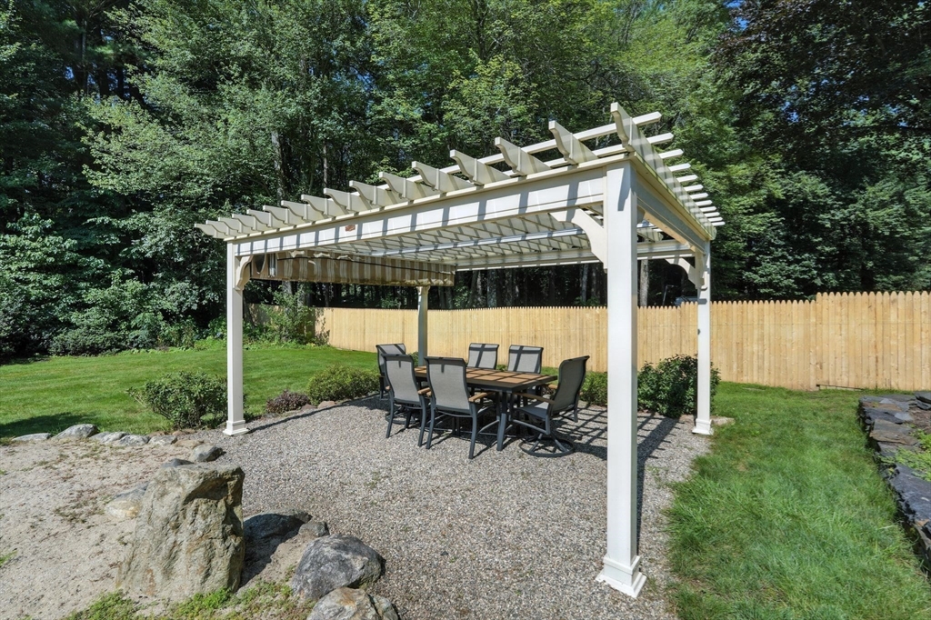 53 Yankee Circle Westfield, MA 01085 - Photo 7 of 42 a view of a patio with table and chairs under an umbrella with large trees