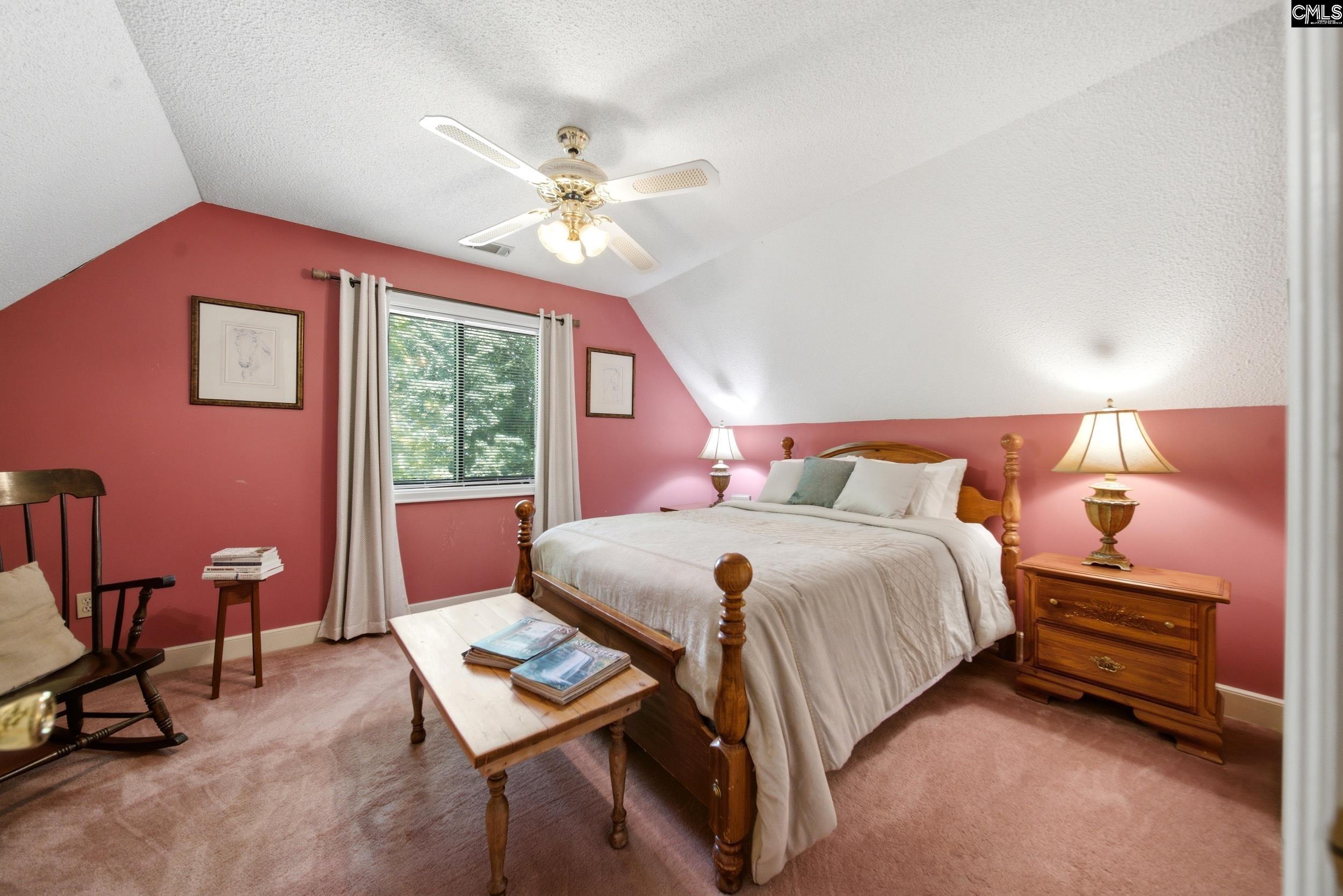 4324 Syrup Mill Road Ridgeway, SC 29130 - Photo 34 of 61 a bedroom with a bed a chandelier and a chair