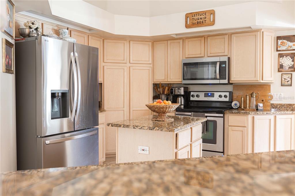 1915 Southwest 40th Place Ocala, FL 34471 - Photo 12 of 20 a kitchen with stainless steel appliances granite countertop a refrigerator a stove a sink a microwave and cabinets
