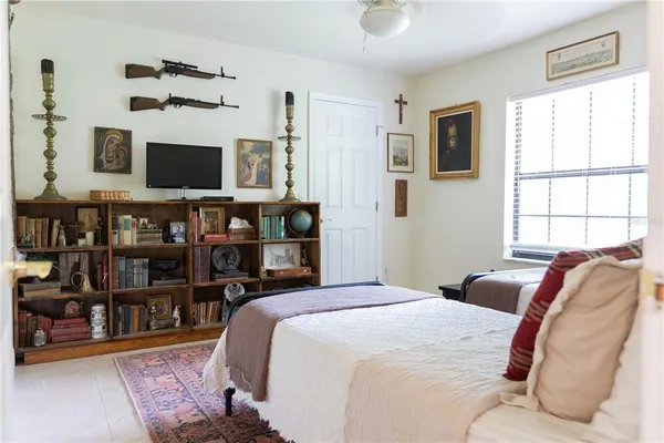 a bedroom with a bed a flat screen tv and dresser