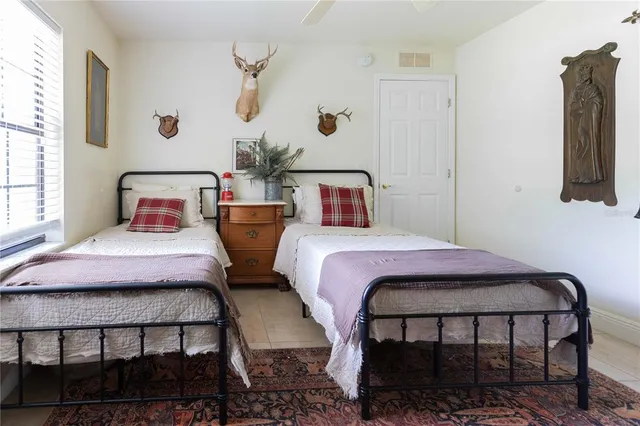 a bedroom with two beds and potted plants