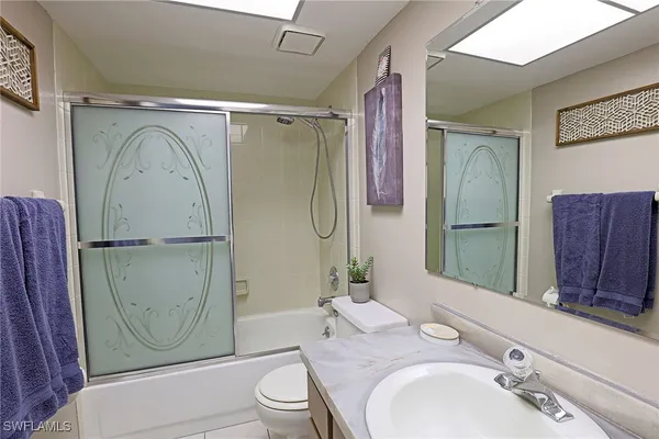 a bathroom with a granite countertop toilet sink and shower