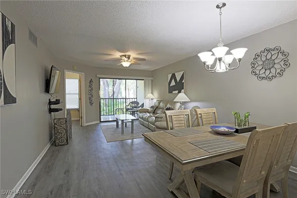 a view of a dining room with furniture a chandelier and wooden floor