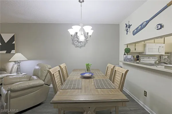 a view of a dining room with furniture a chandelier and wooden floor