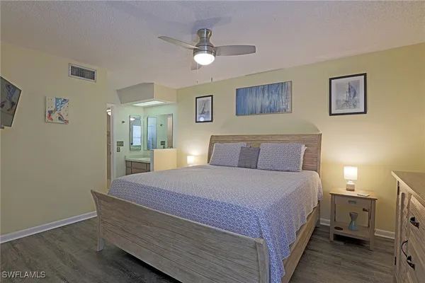 a spacious bedroom with a bed and a chandelier